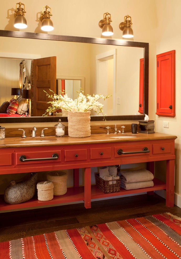 Rustikales Badezimmer mit Waschtisch aus Holz, roten Schränken, dunklem Holzboden, Unterbauwaschbecken und brauner Waschtischplatte in Denver