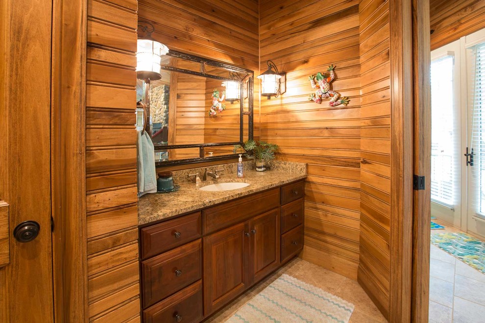 Mountain style brown floor bathroom photo in Other with raised-panel cabinets, dark wood cabinets, brown walls and an undermount sink
