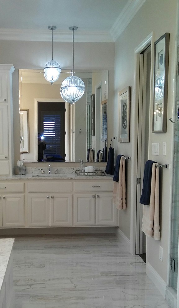 Inspiration for a large classic ensuite bathroom in Dallas with raised-panel cabinets, white cabinets, a built-in bath, white tiles, beige walls, quartz worktops, a submerged sink, an alcove shower, marble tiles, marble flooring, grey floors and a hinged door.