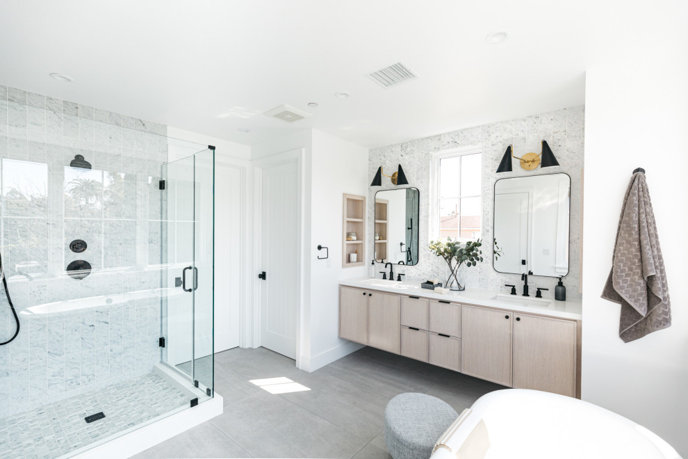 Freestanding bathtub - large transitional master marble tile terrazzo floor and gray floor freestanding bathtub idea in Los Angeles with light wood cabinets, an undermount sink, quartz countertops, a hinged shower door and white countertops
