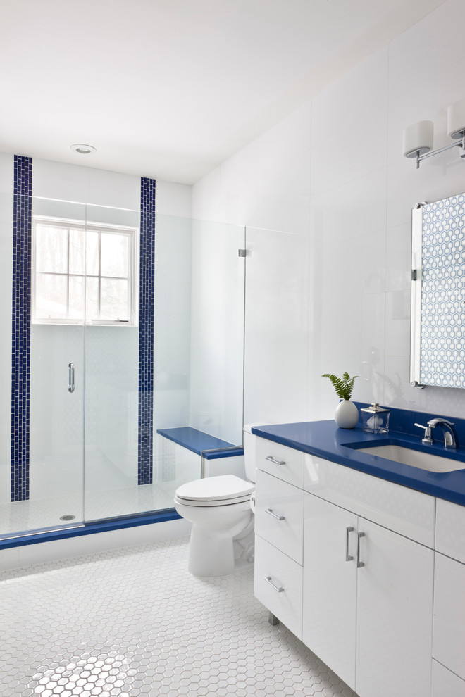 Aménagement d'une salle de bain bord de mer de taille moyenne avec un lavabo encastré, un placard à porte plane, des portes de placard blanches, un mur blanc, un plan de toilette bleu et du carrelage bicolore.