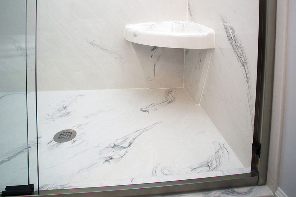 Klassisk inredning av ett mellanstort badrum med dusch, med ett undermonterad handfat, möbel-liknande, skåp i mellenmörkt trä, granitbänkskiva, en dusch i en alkov, en toalettstol med separat cisternkåpa, flerfärgad kakel, keramikplattor, vita väggar och klinkergolv i keramik