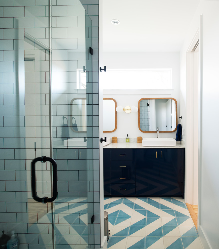 Пример оригинального дизайна: ванная комната в современном стиле с плоскими фасадами, синими фасадами, угловым душем, белой плиткой, плиткой кабанчик, белыми стенами, душевой кабиной, настольной раковиной, разноцветным полом, душем с распашными дверями и белой столешницей