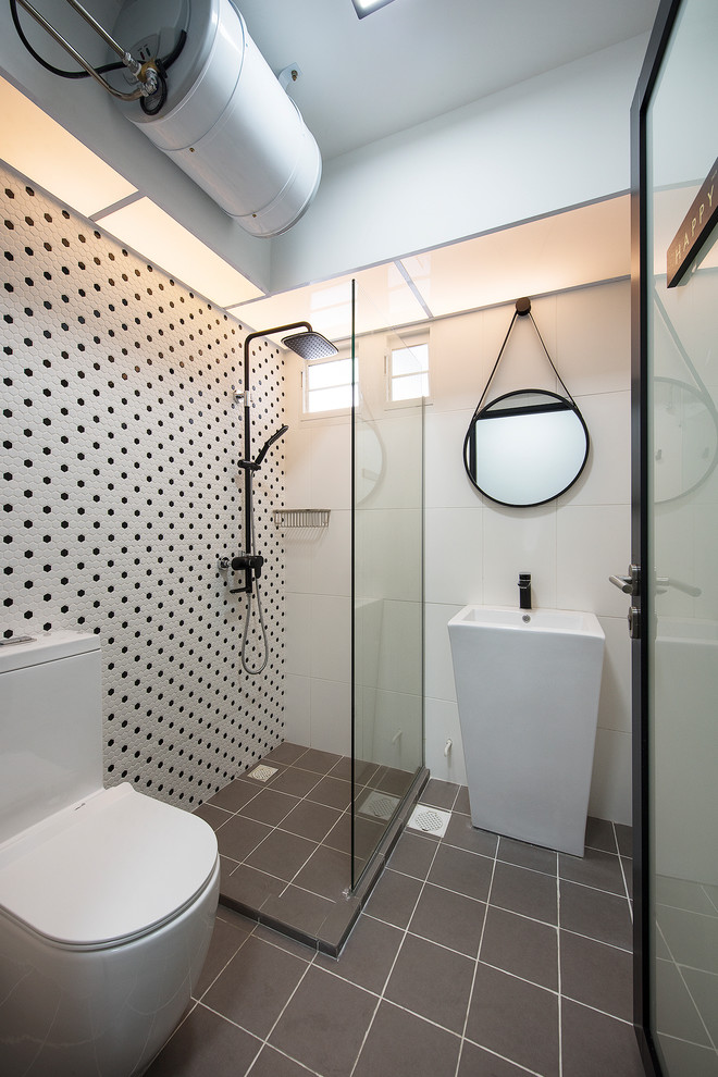 Modelo de cuarto de baño contemporáneo con ducha esquinera, baldosas y/o azulejos blancas y negros, lavabo con pedestal, suelo gris y ducha abierta
