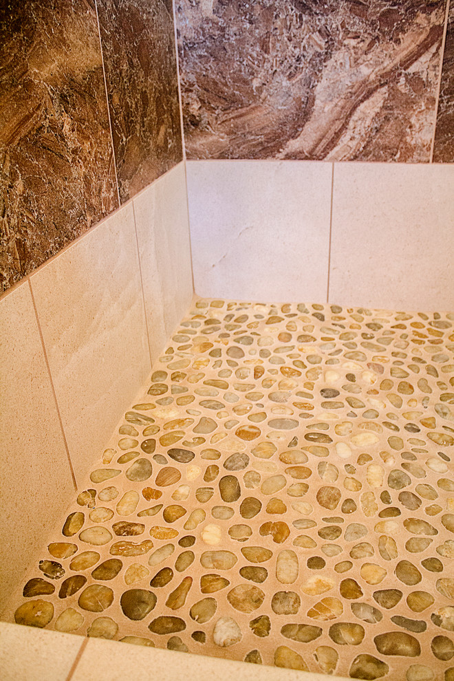 Modelo de cuarto de baño principal rural de tamaño medio con ducha doble, baldosas y/o azulejos beige, suelo de baldosas tipo guijarro y paredes beige