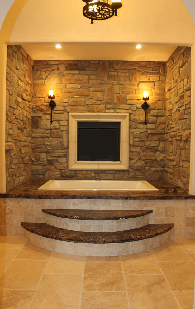 Идея дизайна: большая главная ванная комната в средиземноморском стиле с мраморной столешницей, накладной ванной, бежевой плиткой, каменной плиткой и полом из травертина