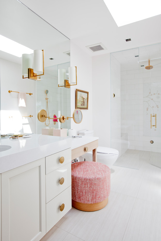 Inspiration for a transitional white tile beige floor walk-in shower remodel in Vancouver with recessed-panel cabinets, white cabinets, white walls, an undermount sink and a hinged shower door