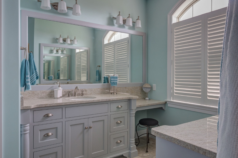 Modelo de cuarto de baño clásico de tamaño medio con paredes azules, suelo de baldosas de cerámica, lavabo bajoencimera, armarios con paneles empotrados, puertas de armario blancas, aseo y ducha y encimera de granito