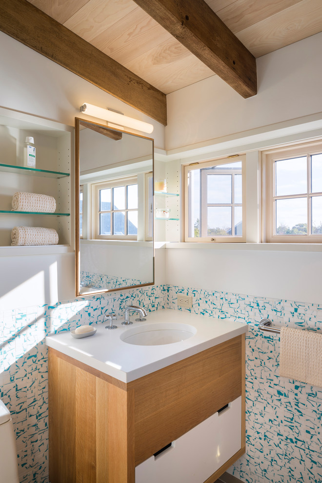 На фото: ванная комната в морском стиле с плоскими фасадами, светлыми деревянными фасадами, разноцветными стенами, врезной раковиной, белой столешницей и зеркалом с подсветкой