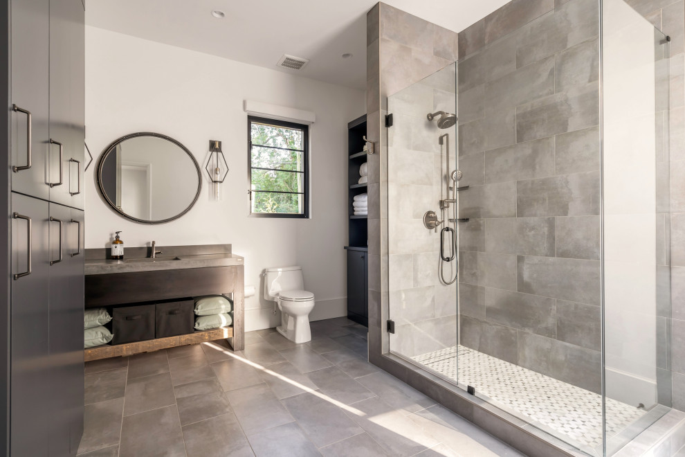This is an example of a traditional bathroom in Atlanta with a corner shower, grey tiles, white walls, grey floors, a hinged door, grey worktops, a single sink and a freestanding vanity unit.