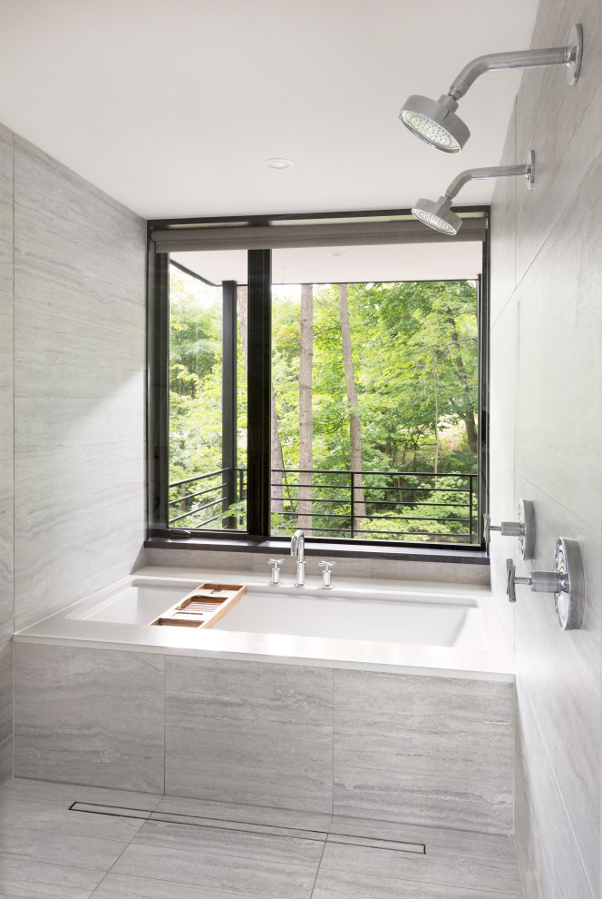 Inspiration for a medium sized modern ensuite bathroom in Milwaukee with flat-panel cabinets, a submerged bath, a double shower, grey tiles, porcelain tiles, white walls, porcelain flooring, a submerged sink, engineered stone worktops, grey floors, an open shower, white worktops and light wood cabinets.