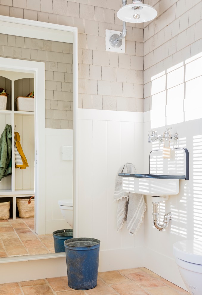 Klassisches Badezimmer mit Wandtoilette, farbigen Fliesen, bunten Wänden, Terrakottaboden, Wandwaschbecken und orangem Boden in Boston
