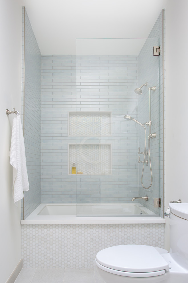 На фото: ванная комната в морском стиле с фасадами в стиле шейкер, серыми фасадами, полновстраиваемой ванной, душем над ванной, унитазом-моноблоком, синей плиткой, мраморной плиткой, белыми стенами, полом из керамической плитки, врезной раковиной, столешницей из кварцита, бежевым полом, душем с распашными дверями и белой столешницей