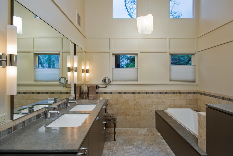 Imagen de cuarto de baño contemporáneo con lavabo bajoencimera, armarios con paneles lisos, puertas de armario de madera en tonos medios, bañera encastrada, baldosas y/o azulejos beige y baldosas y/o azulejos de cemento