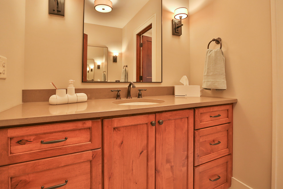 Exempel på ett mellanstort lantligt badrum med dusch, med luckor med infälld panel, skåp i mellenmörkt trä, en öppen dusch, beige kakel, beige väggar och ett undermonterad handfat