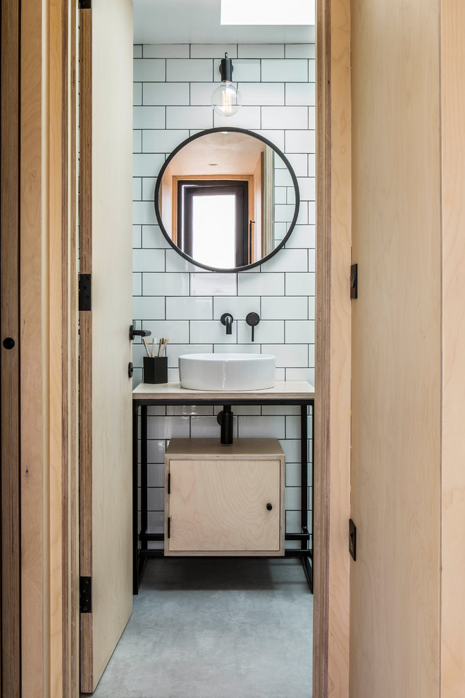 Идея дизайна: ванная комната в скандинавском стиле с плоскими фасадами, светлыми деревянными фасадами, белой плиткой, плиткой кабанчик, белыми стенами, бетонным полом, настольной раковиной, столешницей из дерева, серым полом, бежевой столешницей и зеркалом с подсветкой