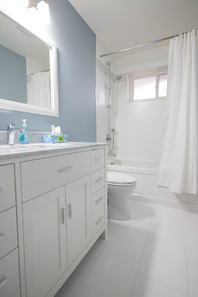 Mid-sized trendy master white tile and stone slab medium tone wood floor alcove shower photo in Toronto with an undermount sink, recessed-panel cabinets, distressed cabinets, quartzite countertops, a one-piece toilet and gray walls