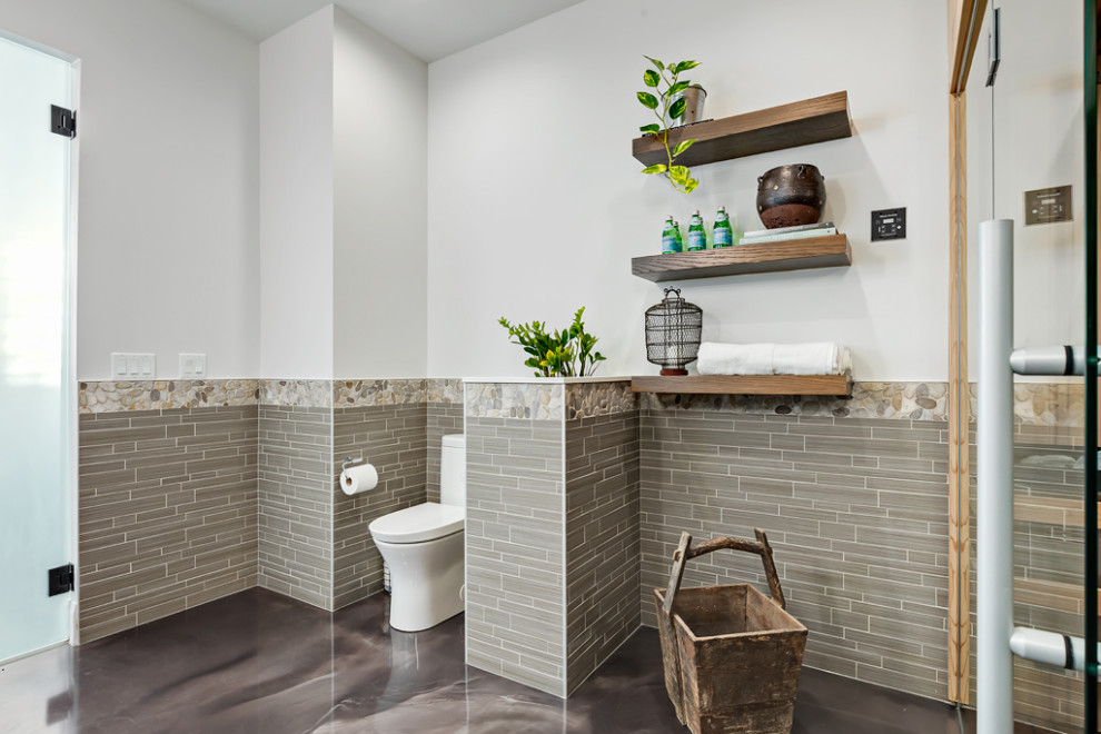 Trendy gray tile and wood-look tile concrete floor, gray floor, single-sink and wall paneling bathroom photo in Calgary with light wood cabinets, a one-piece toilet, white walls, a vessel sink, quartz countertops, white countertops, a niche and a freestanding vanity