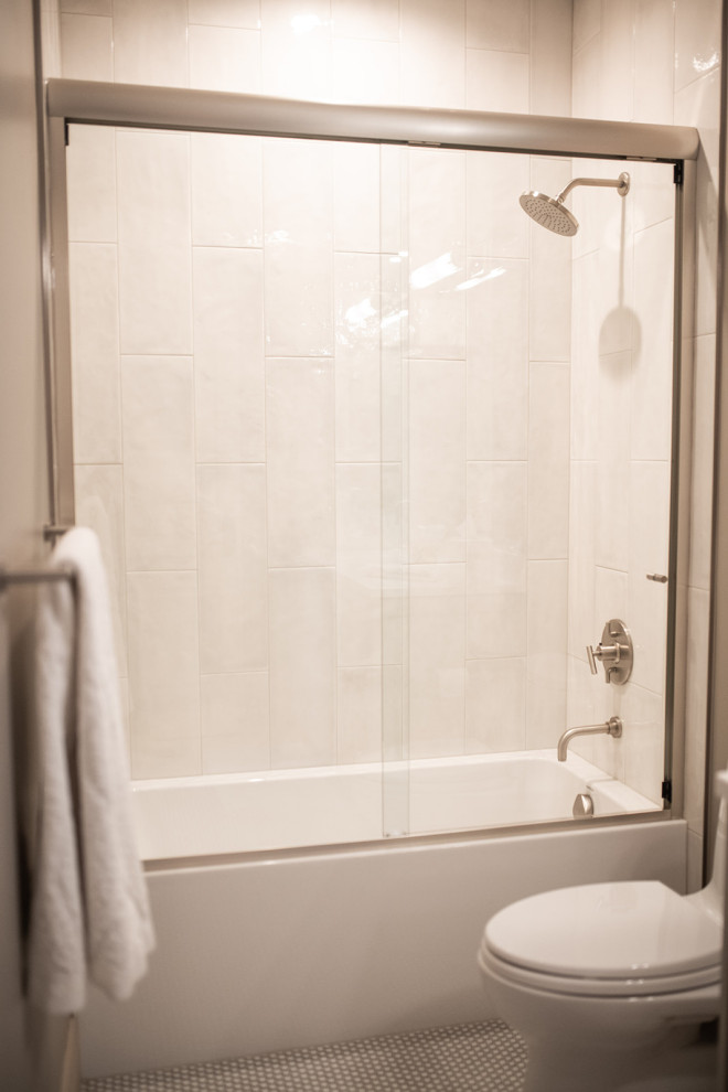 На фото: ванная комната среднего размера в современном стиле с фасадами в стиле шейкер, белыми фасадами, ванной в нише, душем над ванной, унитазом-моноблоком, бежевой плиткой, керамической плиткой, бежевыми стенами, полом из керамической плитки, душевой кабиной, врезной раковиной, столешницей из искусственного кварца, бежевым полом, душем с раздвижными дверями, белой столешницей, нишей, тумбой под одну раковину и встроенной тумбой