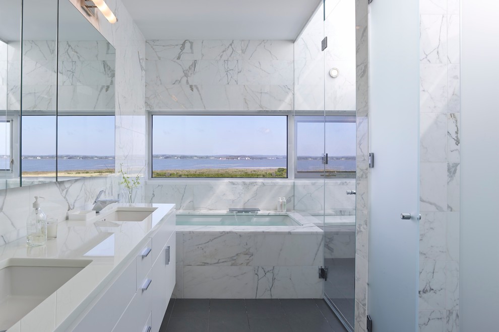 На фото: главная ванная комната в современном стиле с врезной раковиной, плоскими фасадами, белыми фасадами, полновстраиваемой ванной, белой плиткой и окном с