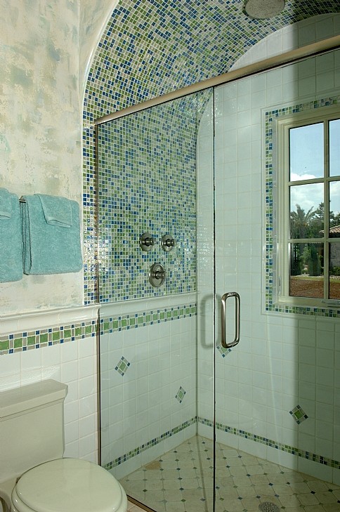Exempel på ett medelhavsstil badrum, med en dusch i en alkov, blå kakel, grön kakel, mosaik, flerfärgade väggar, kalkstensgolv, beiget golv och dusch med gångjärnsdörr