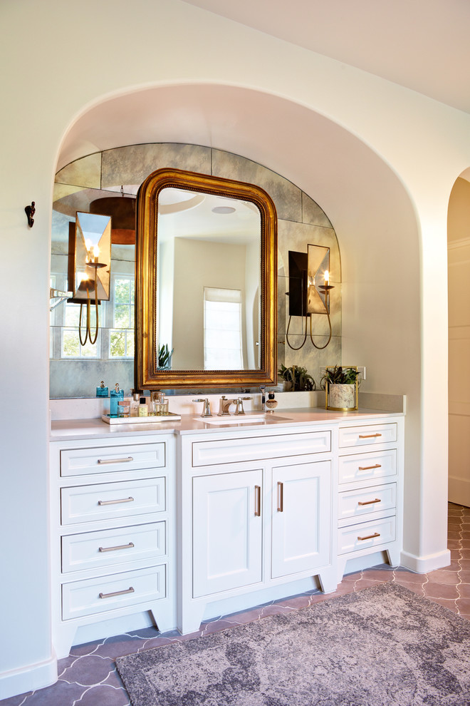 На фото: большая главная ванная комната в средиземноморском стиле с фасадами с утопленной филенкой, белыми фасадами, керамической плиткой, белыми стенами, полом из керамической плитки и врезной раковиной