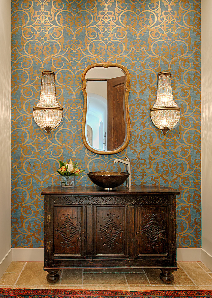 Medelhavsstil inredning av ett badrum, med ett fristående handfat, skåp i mörkt trä, flerfärgade väggar och luckor med infälld panel
