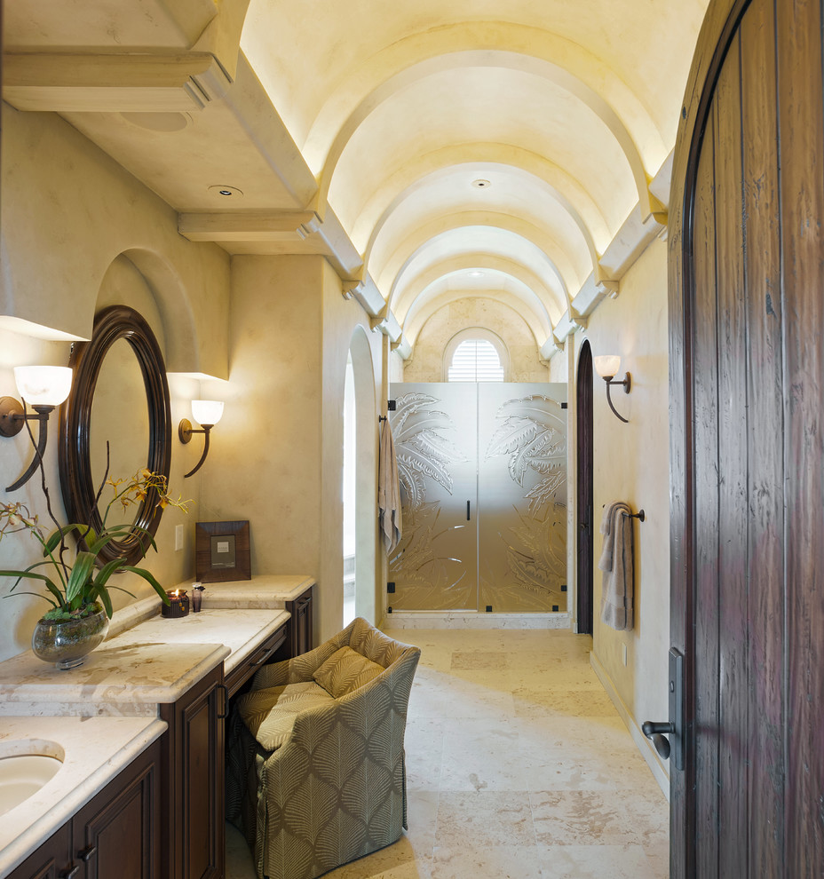 На фото: ванная комната в средиземноморском стиле с врезной раковиной, темными деревянными фасадами, душем в нише, бежевой плиткой и бежевыми стенами с