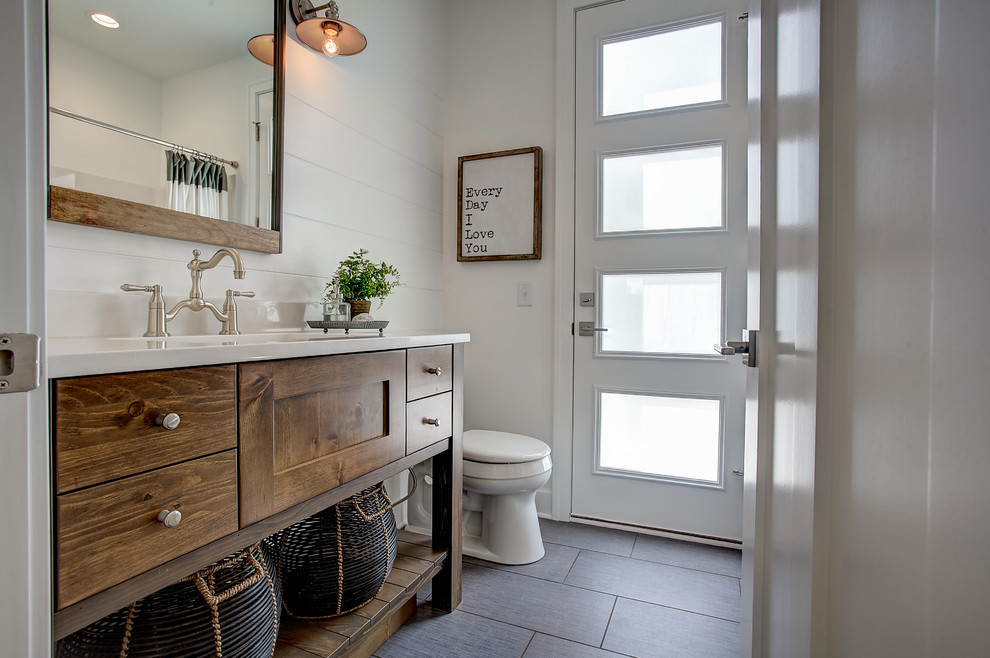 Idee per una stanza da bagno con doccia mediterranea con ante lisce, ante in legno bruno, pareti bianche, lavabo integrato e pavimento grigio