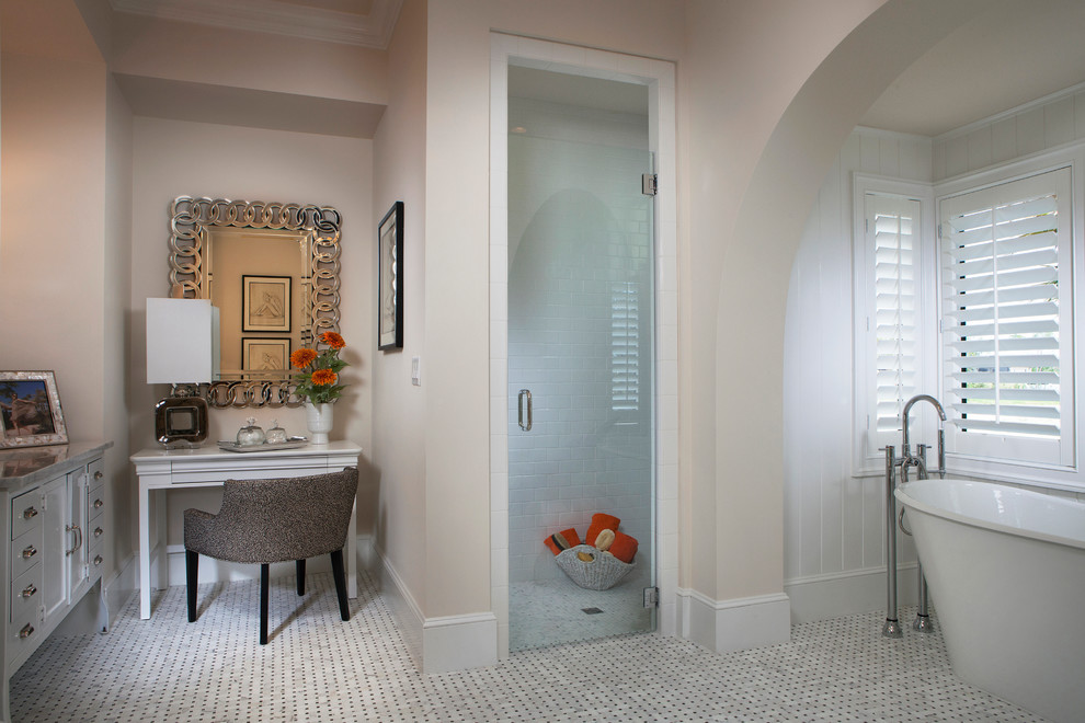 This is an example of a mediterranean ensuite bathroom in Other with white cabinets, a freestanding bath, a built-in shower, multi-coloured tiles, beige walls and shaker cabinets.