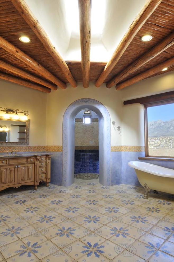 На фото: ванная комната в средиземноморском стиле с ванной на ножках с