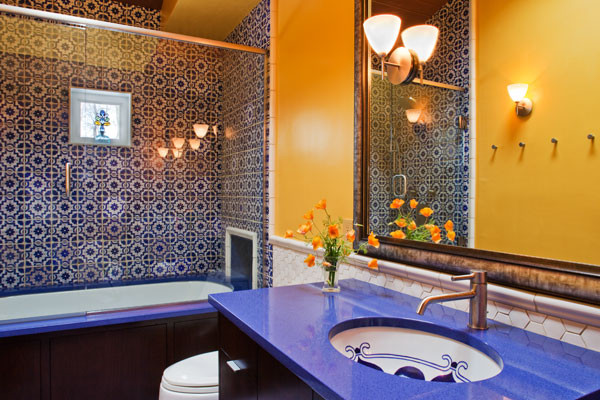 Источник вдохновения для домашнего уюта: детская ванная комната среднего размера в средиземноморском стиле с врезной раковиной, плоскими фасадами, темными деревянными фасадами, столешницей из искусственного кварца, полновстраиваемой ванной, душем над ванной, унитазом-моноблоком, синей плиткой, желтыми стенами и синей столешницей