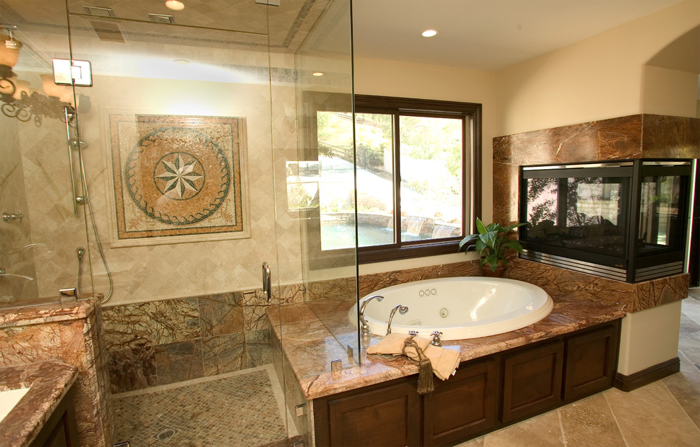 Example of a huge tuscan master beige tile, multicolored tile and porcelain tile travertine floor and beige floor bathroom design in Orange County with recessed-panel cabinets, dark wood cabinets, a one-piece toilet, beige walls, a drop-in sink, granite countertops and a hinged shower door
