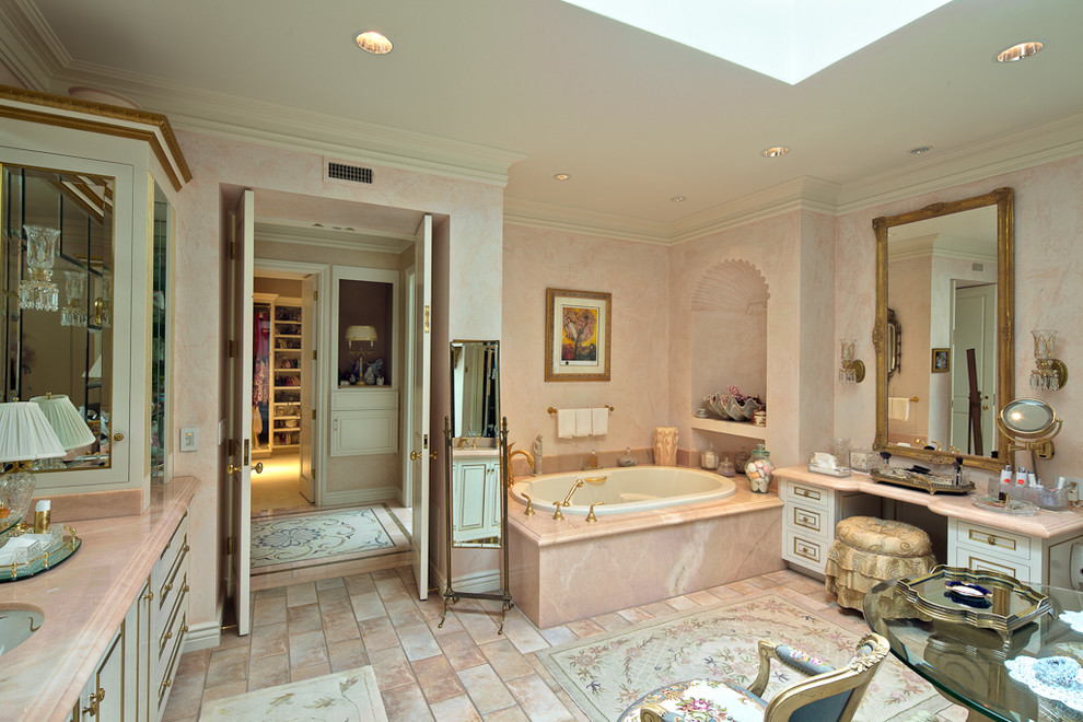 Пример оригинального дизайна: большая главная ванная комната в средиземноморском стиле с фасадами островного типа, белыми фасадами, накладной ванной, розовой плиткой, плиткой из листового камня, розовыми стенами, полом из керамогранита, врезной раковиной, столешницей из искусственного кварца, розовым полом и розовой столешницей