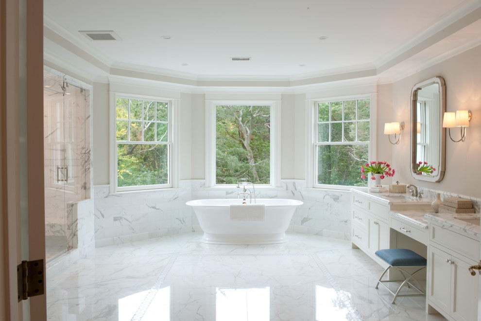 Huge beige tile and marble tile marble floor, multicolored floor, double-sink and vaulted ceiling bathroom photo in Boston with beaded inset cabinets, white cabinets, a one-piece toilet, beige walls, an integrated sink, marble countertops, a hinged shower door, white countertops and a built-in vanity