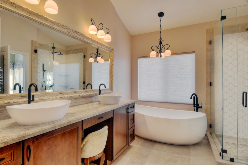 Inspiration for a mid-sized mediterranean master beige tile and stone tile travertine floor bathroom remodel in San Diego with a vessel sink, raised-panel cabinets, dark wood cabinets, a two-piece toilet and beige walls