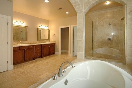Idée de décoration pour une grande salle de bain principale méditerranéenne en bois brun avec un lavabo posé, un placard avec porte à panneau surélevé, un plan de toilette en granite, une baignoire posée, une douche d'angle, un carrelage beige, un carrelage de pierre, un mur beige et un sol en travertin.