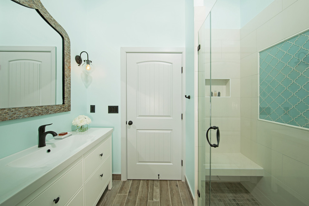 Inspiration for a mid-sized mediterranean master beige tile and ceramic tile ceramic tile and brown floor alcove shower remodel in DC Metro with flat-panel cabinets, white cabinets, blue walls, an integrated sink, a hinged shower door and white countertops