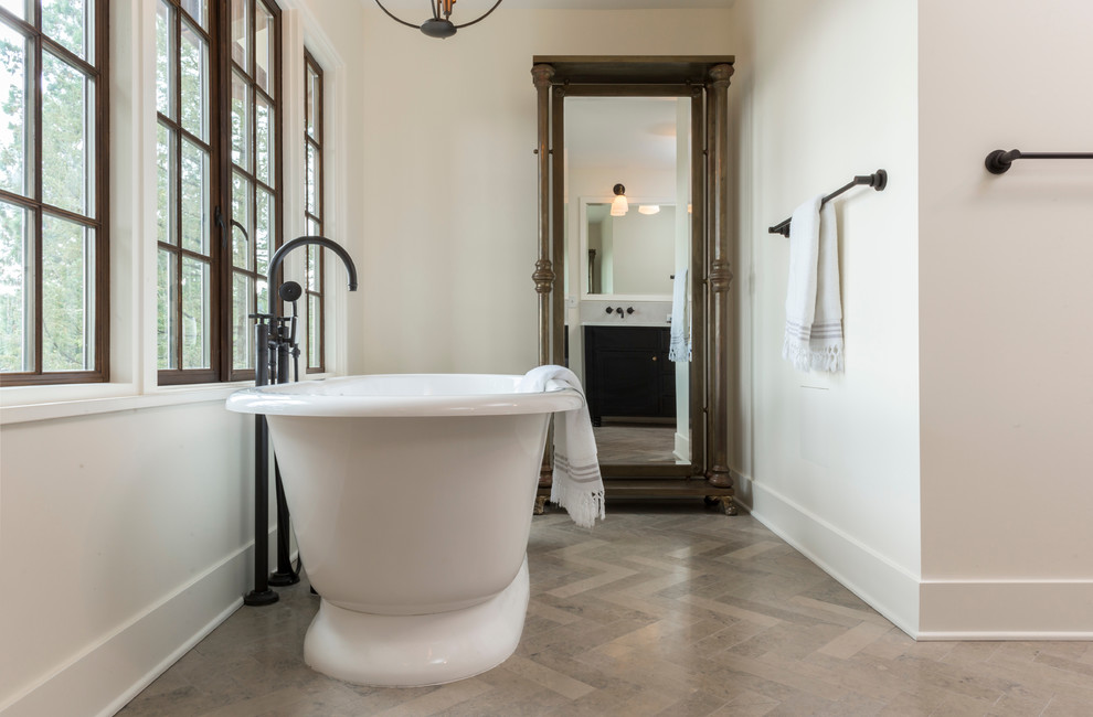 This is an example of a large mediterranean ensuite bathroom in Portland with a freestanding bath, a one-piece toilet, white walls, limestone flooring, a submerged sink, engineered stone worktops, grey floors, a hinged door, recessed-panel cabinets, a corner shower and dark wood cabinets.