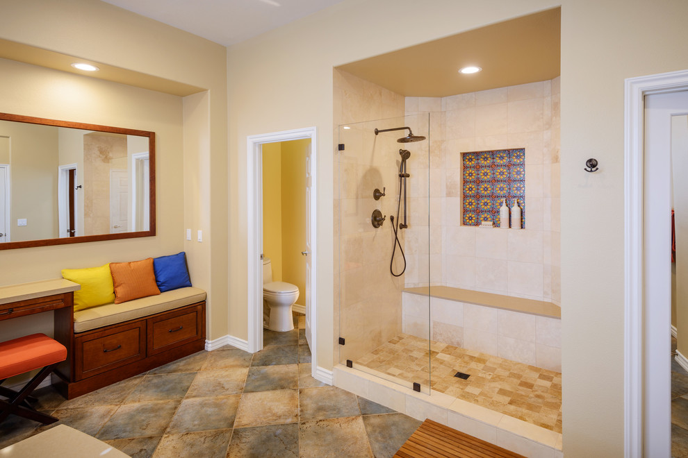 Photo of a large mediterranean ensuite bathroom in Los Angeles with shaker cabinets, medium wood cabinets, a built-in bath, beige tiles, travertine tiles, beige walls, porcelain flooring, a submerged sink, engineered stone worktops, an alcove shower and a one-piece toilet.