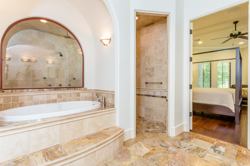 Источник вдохновения для домашнего уюта: большая главная ванная комната в средиземноморском стиле с фасадами в стиле шейкер, белыми фасадами, накладной ванной, двойным душем, раздельным унитазом, бежевой плиткой, плиткой из травертина, белыми стенами, полом из травертина, врезной раковиной, столешницей из гранита, коричневым полом, открытым душем и разноцветной столешницей