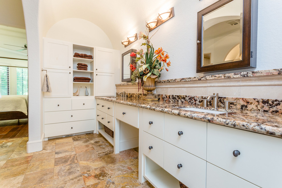 Design ideas for a large mediterranean ensuite bathroom in Houston with shaker cabinets, white cabinets, a built-in bath, a walk-in shower, beige tiles, travertine tiles, white walls, travertine flooring, a submerged sink, granite worktops, beige floors, an open shower and beige worktops.