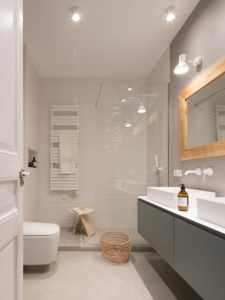 Идея дизайна: ванная комната среднего размера в современном стиле с белой плиткой, керамической плиткой, бежевыми стенами, бежевым полом, открытым душем, плоскими фасадами, серыми фасадами, угловым душем, инсталляцией, душевой кабиной, настольной раковиной, белой столешницей и зеркалом с подсветкой