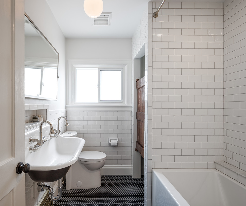 Photo of a small country bathroom in Ottawa with an alcove bath, a shower/bath combination, a two-piece toilet, black and white tiles, metro tiles, white walls, marble flooring and a wall-mounted sink.