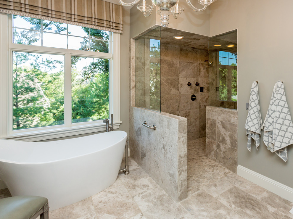 Klassisk inredning av ett stort en-suite badrum, med skåp i shakerstil, bruna skåp, ett fristående badkar, en öppen dusch, beige väggar, kalkstensgolv, ett undermonterad handfat och granitbänkskiva
