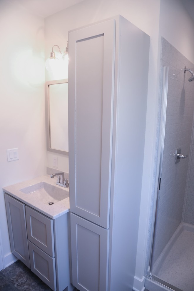 Bild på ett litet vintage grå grått en-suite badrum, med släta luckor, grå skåp, en dusch i en alkov, en toalettstol med separat cisternkåpa, grå kakel, tunnelbanekakel, grå väggar, vinylgolv, ett integrerad handfat, bänkskiva i onyx, grått golv och dusch med gångjärnsdörr