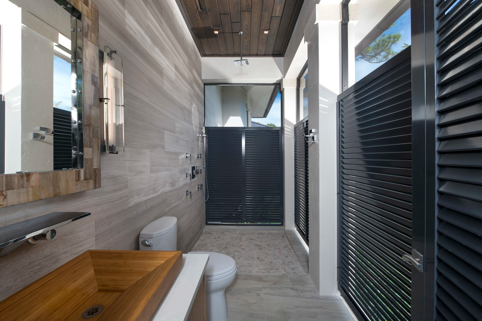 Inspiration for a contemporary ensuite bathroom in Orlando with flat-panel cabinets, dark wood cabinets, grey tiles and grey floors.