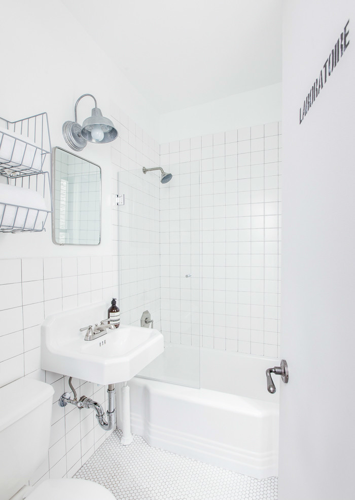 Idéer för att renovera ett litet eklektiskt en-suite badrum, med ett väggmonterat handfat, öppna hyllor, grå skåp, ett badkar i en alkov, en dusch/badkar-kombination, en toalettstol med separat cisternkåpa, vit kakel, keramikplattor, vita väggar och mosaikgolv