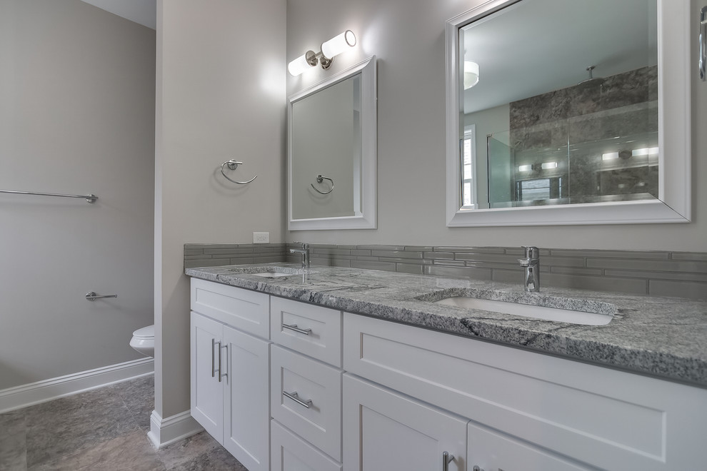 Idee per una stanza da bagno padronale design con ante in stile shaker, ante bianche, piastrelle grigie, pavimento in travertino e top in granito