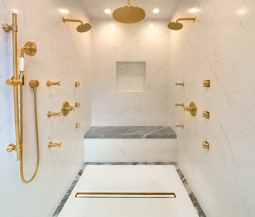 Exempel på ett mycket stort klassiskt en-suite badrum, med grå skåp, ett fristående badkar, en kantlös dusch, en vägghängd toalettstol, vit kakel, porslinskakel, vita väggar, klinkergolv i porslin, ett nedsänkt handfat, marmorbänkskiva, vitt golv och dusch med gångjärnsdörr